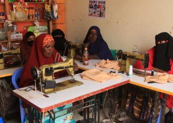 Alt text: Skills training conducted by Wadani Institute for dispossessed Somali pastoralists living in Badbado IDP camp in Adado, Galgadud, has enabled them to make a new living to support their families and their children’s education. 30 women trained in tailoring have set up a cooperative and are working for the first time.